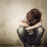 angry and sad kid leaning against wall dealing with CDV