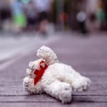 child's bear toy laying on ground