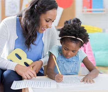 Untitled (700 x 600 px) - 5 A woman working with a child on a worksheet